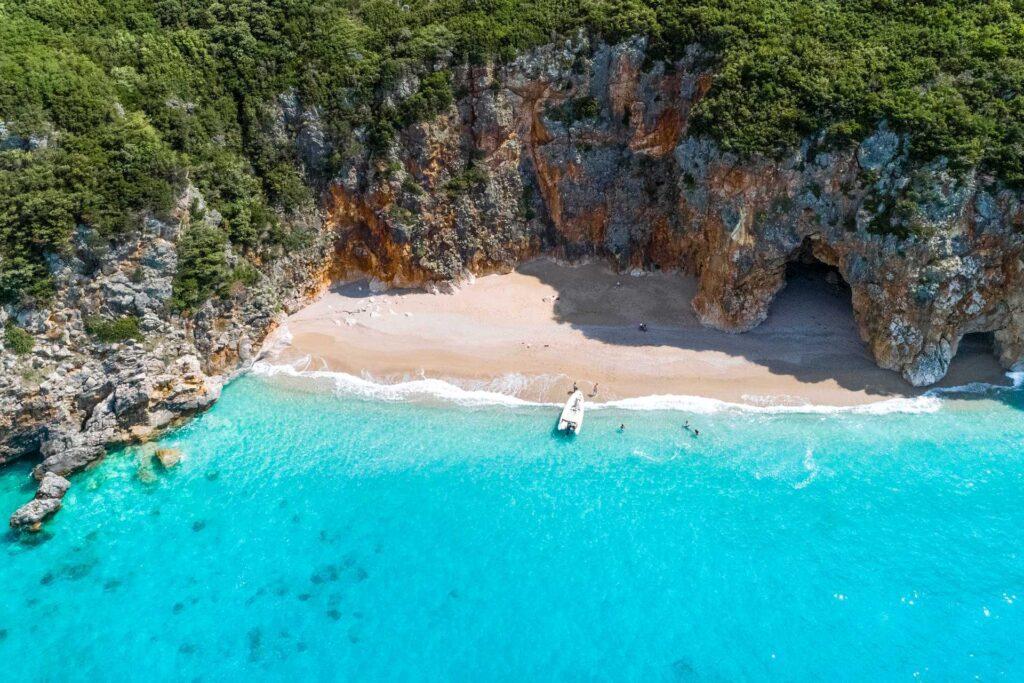 Bilde av vakker strand med båt i albania, syden hvor du kan booke din sommerferie