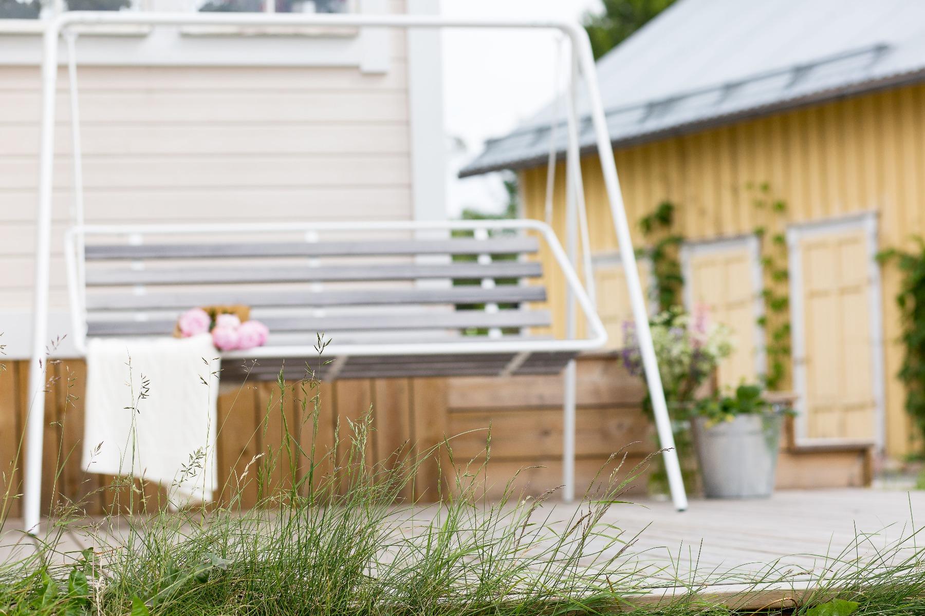 Hammock på terrasse med peoner foran hus