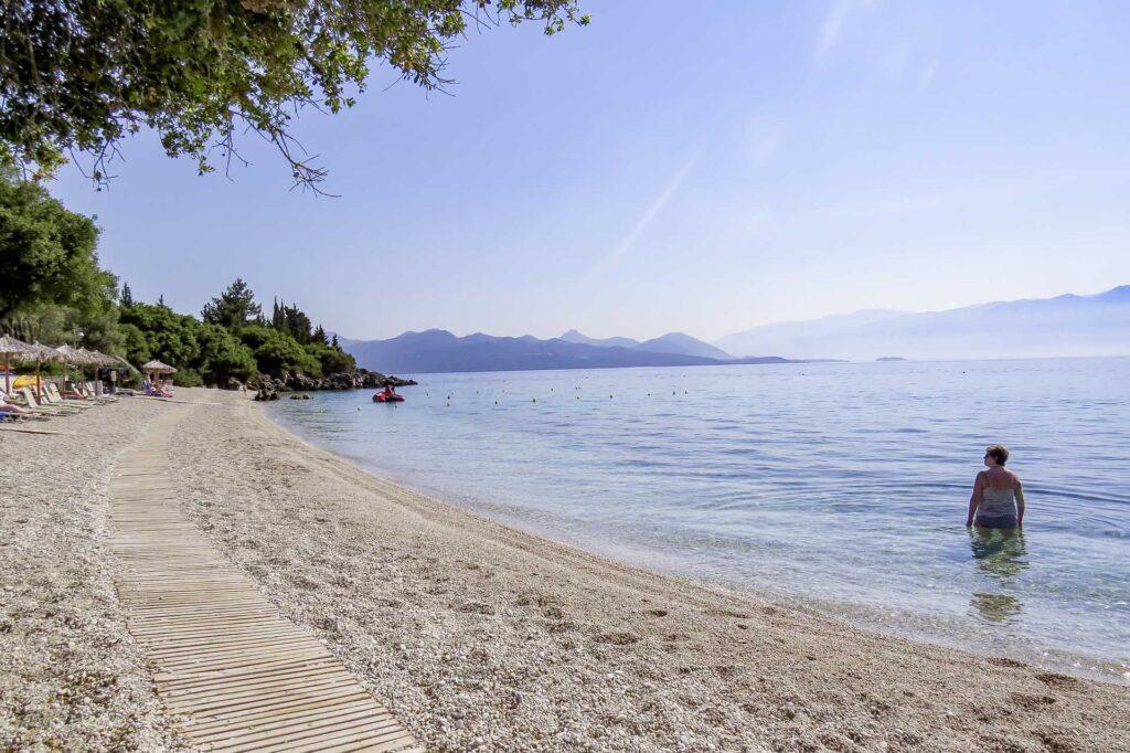 Bilde fra sommerferie i syden på greske Lefkas. Bilde av kvinne på sandstrand med skinnende sol.