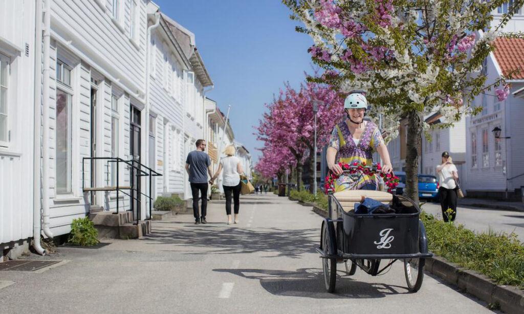 kvinne sykler påå transportsykkel gjennom posebyen i kristiansand