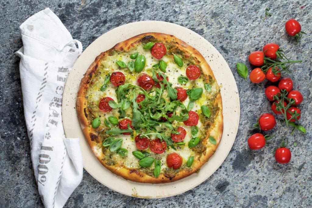 Italiensk pizza med rucola, cherrytomater og pesto.