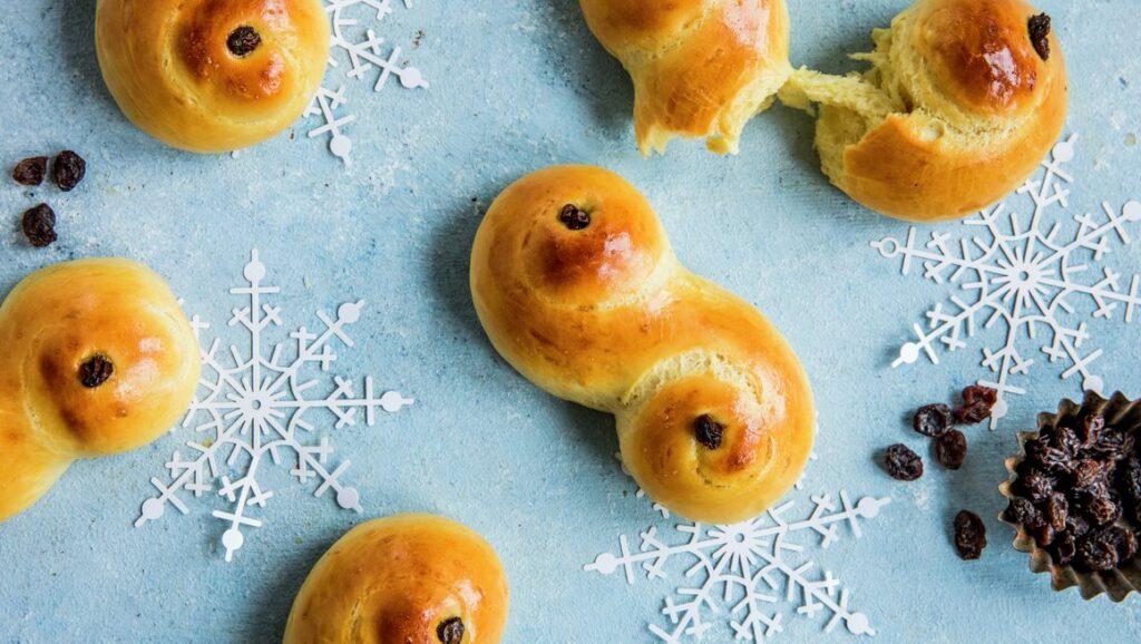 bilde av luftige lussekatter på brett med snøflak-dekor og rosiner