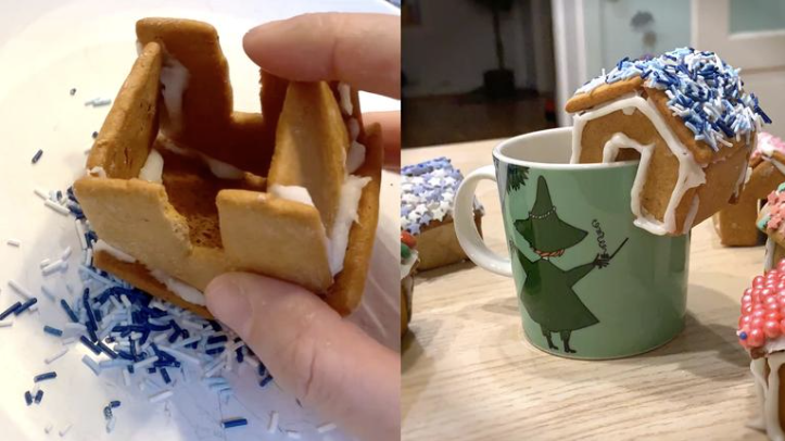 Mini-pepperkake hus som sitter på kanten av kaffekoppen. 