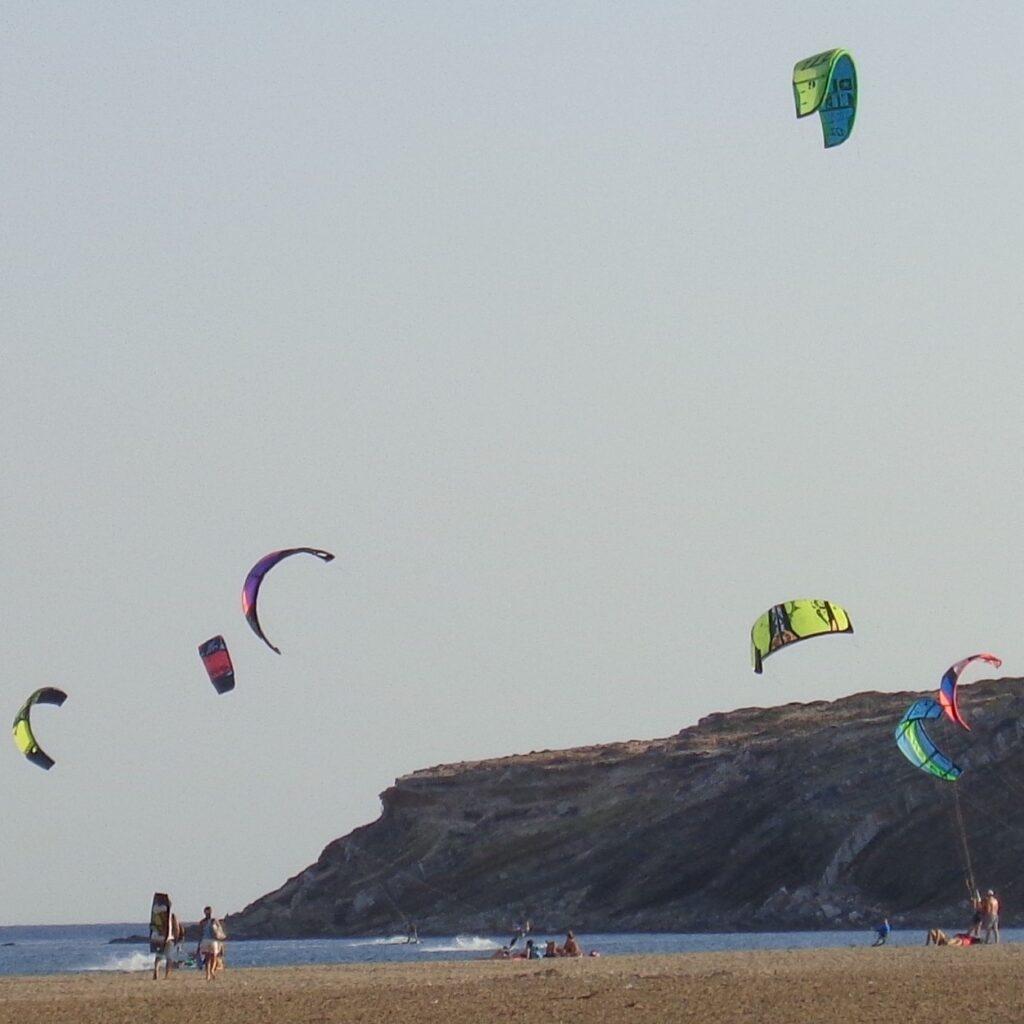 Bilde av flere kiter på den populære Prasonisi-stranden på øya Rhodos i Hellas. Rhodos i Hellas er en drøm, og her får du både billige reiser og pakkereiser til den greske øya. Vi gir deg også fem ting du må se og gjøre på Rhodos, samt svar på ofte stilte spørsmål om øya.