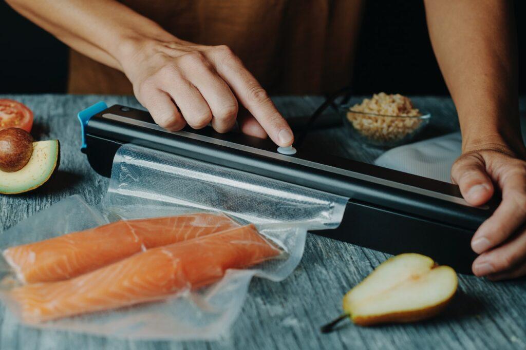 Vakuumpakker best i test: En person vakuumpakker mat på et grått bord.