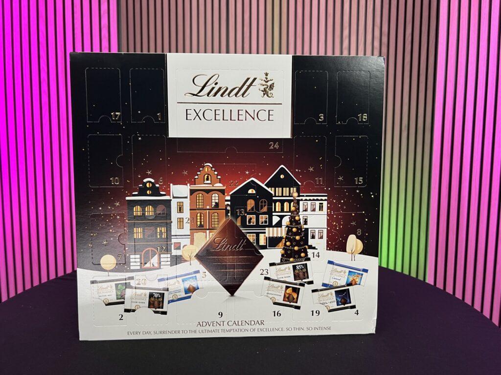 Bilde av lindt excellence julekalender. I bakgrunnen er det rosa farget lys