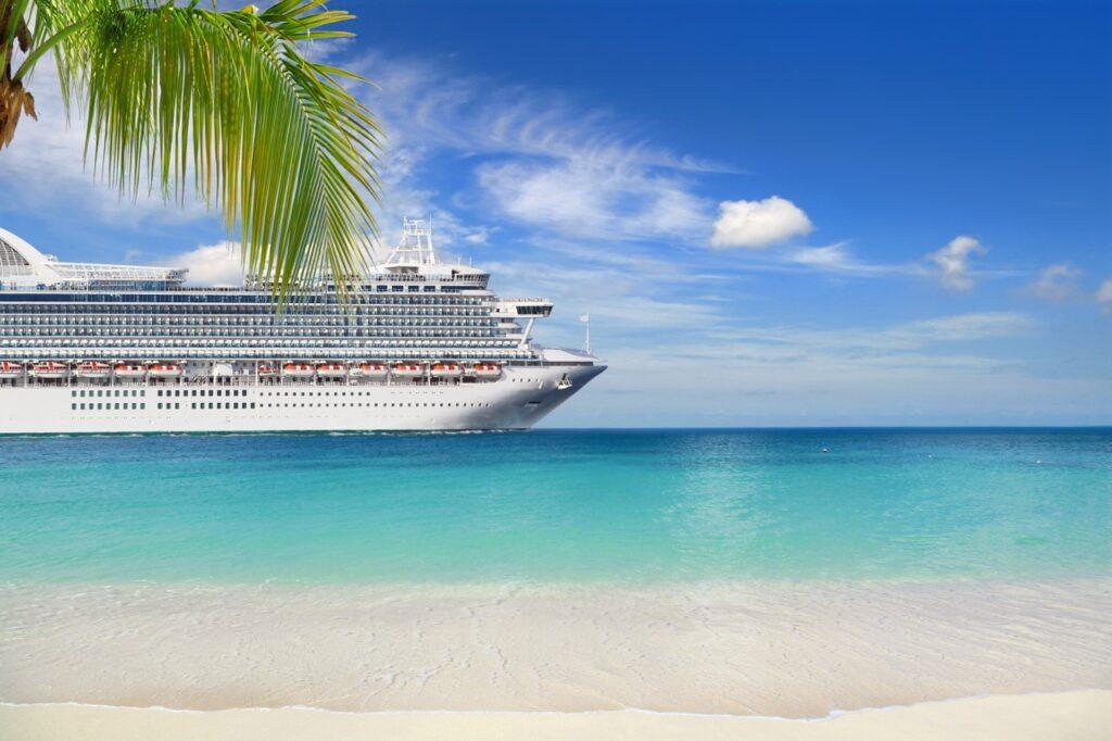 Bilde av et stort cruiseship på krystallblått hav og klar blå himmel. Her finner du en guide til cruise i Karibia, eller Karibien som mange sier. Vi svarer på spørsmål som Hvor er Karibia, Nåer er det best å reise på cruise i Karibia, Hva er beste cruise i Karibia, Hvilken øy i Karibia er best.