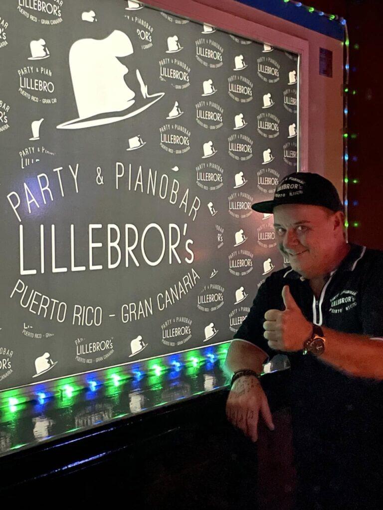 Bilde av Lillebror Sande Larsen som gir tmmel opp ved baren hans Lillebrors Party & Pianobar på Gran Canaria. Her kan du lese Lillebror Sande Larsens guide til Gran Canaria.