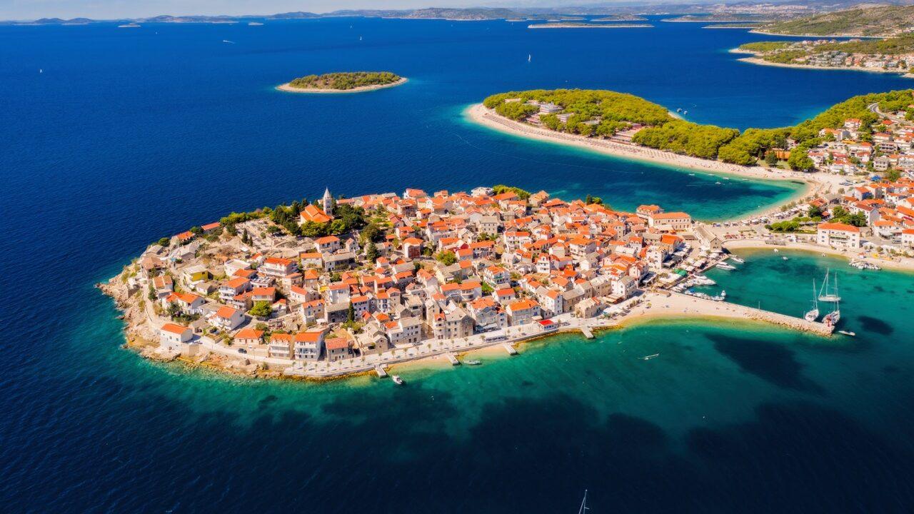 Bilde av Kroatia og gamlebyen. PÅ bilde se vi en liten halvøy med klassisk middelhavsbegyggelse. Restplass til Kroatia