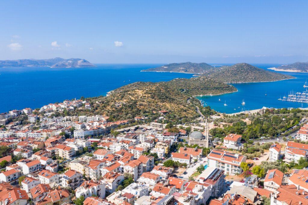 Utsiktsbilde av Antalya i Tyrkia. Her ser du grønne øyer og knallblått hav. I forgrunnen er flere hus med røde tak. Vi hjelper deg med å finne den beste reisen til Tyrkia for deg ved å fortelle om hva du kan gjøre i blant annet Antalya, Side og Alanya.