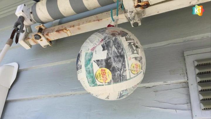 En ball laget av pappmasje som henger fra en markise på terrassen.