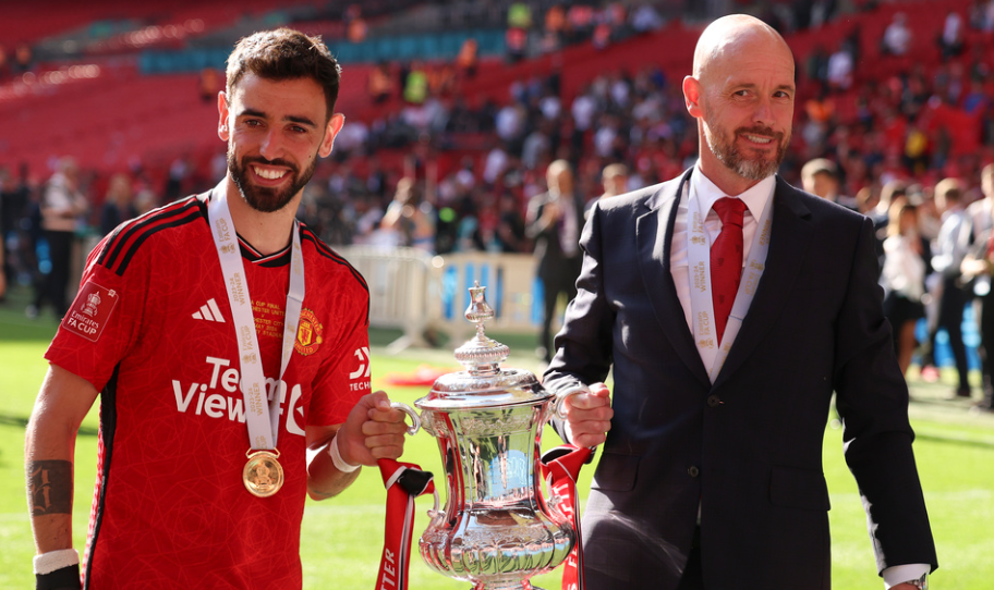 Manchester United's head coach Erik ten Hag and Manchester United's Bruno Fernandes pose with the trophy after winning the English FA Cup final soccer match between Manchester City and Manchester United at Wembley Stadium in London, Saturday, May 25, 2024