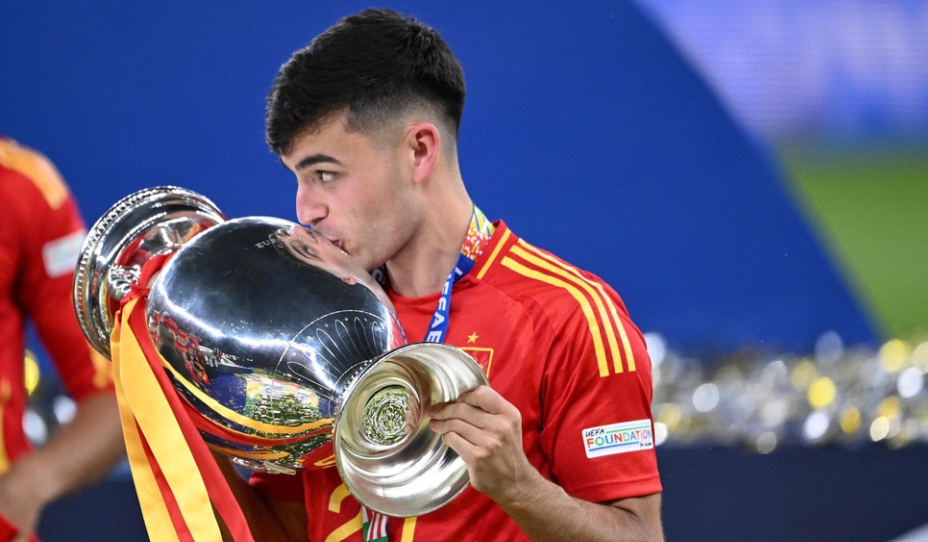 Spain's midfielder #20 Pedri celebrates with the trophy after winning the UEFA Euro 2024 final football match between Spain and England at the Olympiastadion in Berlin on July 14, 2024