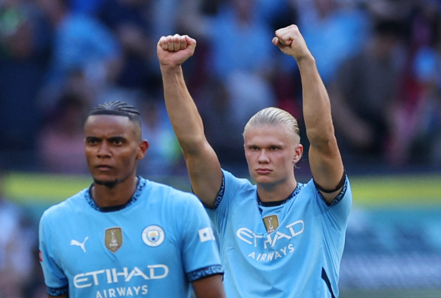 Soccer Football - Community Shield - Manchester United v Manchester City - Wembley Stadium, London, Britain - August 10, 2024 Manchester City's Manuel Akanji and Erling Braut Haaland celebrate after winning the Community Shield