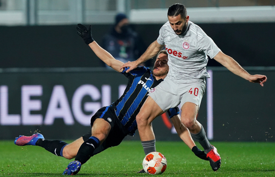 Olympiacos' Kostas Manolas, right, is challenged by Atalanta's Mario Pasalic during the Europa League, round of 16 soccer match between Atalanta and Olympiacos, at the Gewiss stadium in Bergamo, Italy, Thursday, Feb. 17, 2022.