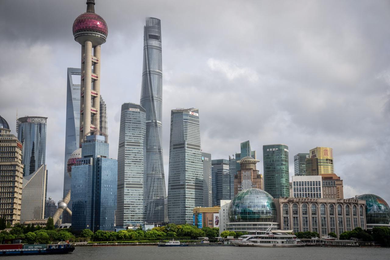 Shanghais ikoniske skyline med høyhus og moderne arkitektur, sett fra vannet.