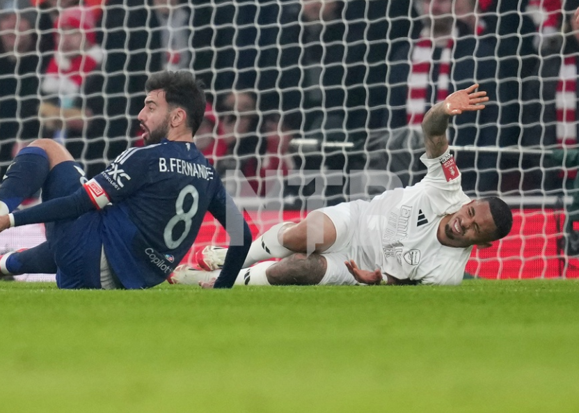 Arsenal's Gabriel Jesus, bottom right, reacts after injuring during the English FA Cup soccer match between Arsenal and Manchester United at the Emirates stadium in London, Sunday, Jan. 12, 2025. 