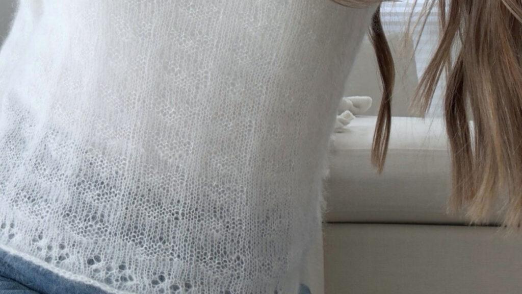 «Usynlige hjerter» er en feminin mohairgenser med rund hals og kroppsnær passform. Genseren strikkes uten montering og har et lett fall som gjør den perfekt til bruk over jeans eller skjørt.