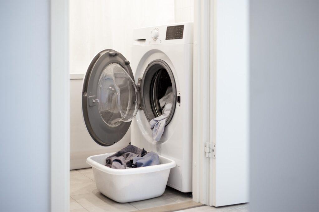 Bilde av en hvit vaskemaskin med døren åpen og en kurv nedenfor med rene klær i. Vi har samlet vaskemaskinene som er kåret til best i test. Velg mellom merker som Miele, Electrolux, LG og Bosch, samt vaskemaskin med tørketrommel.