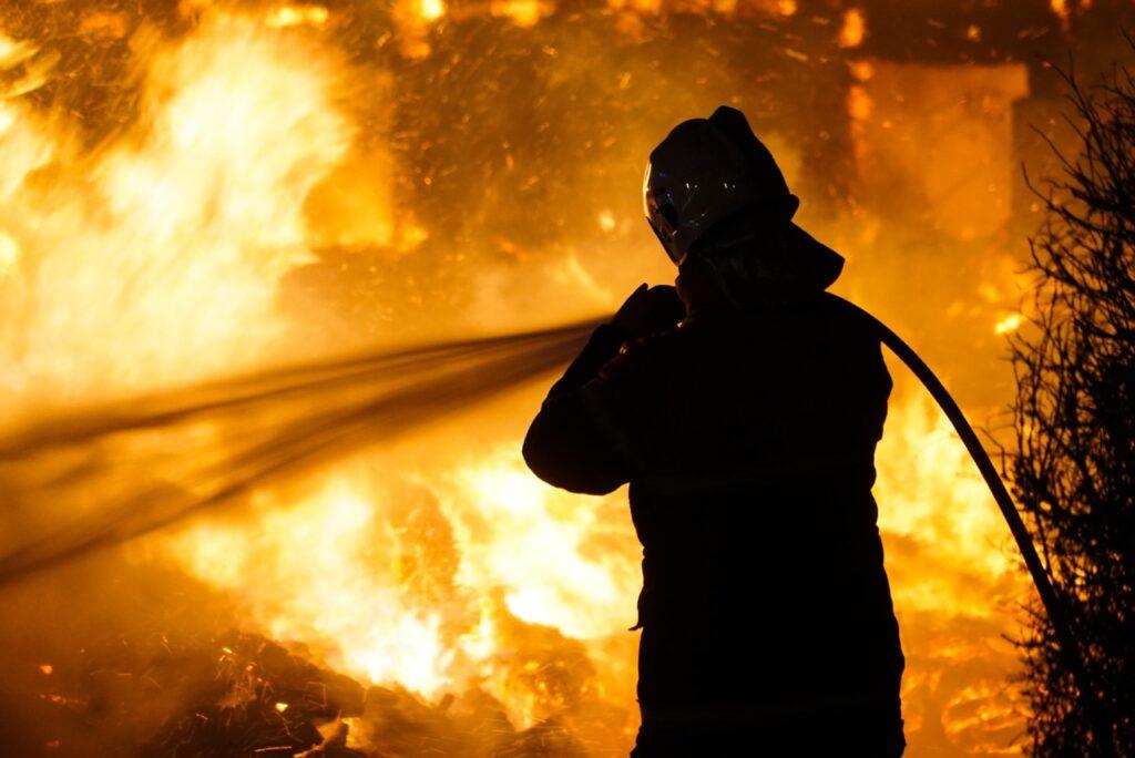 Bilde av en brannmannsom slukker flammer. Vi har snakket med Gaute fra OBR som forteller om brannsikkerhet hjemme.