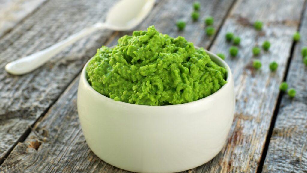 Bilde av grønn ertepuré i hvit skål. Vi gir deg oppskrift på ertepuré.