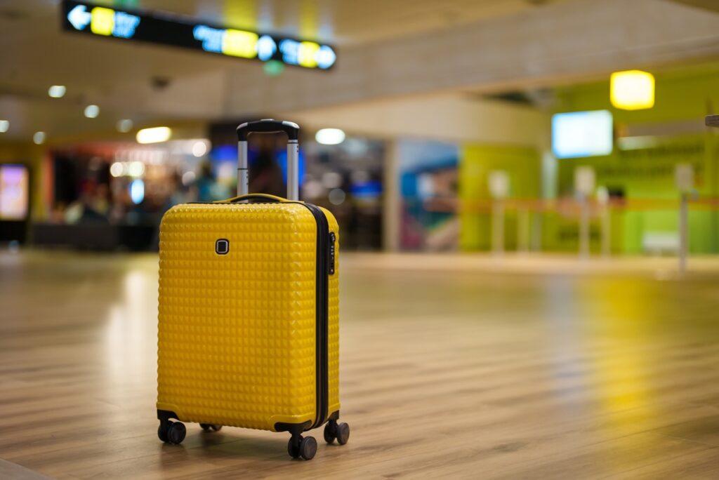 Bagasjeregler for innsjekket bagasje og håndbagasje: En trillekoffert står forlatt på en flyplass.