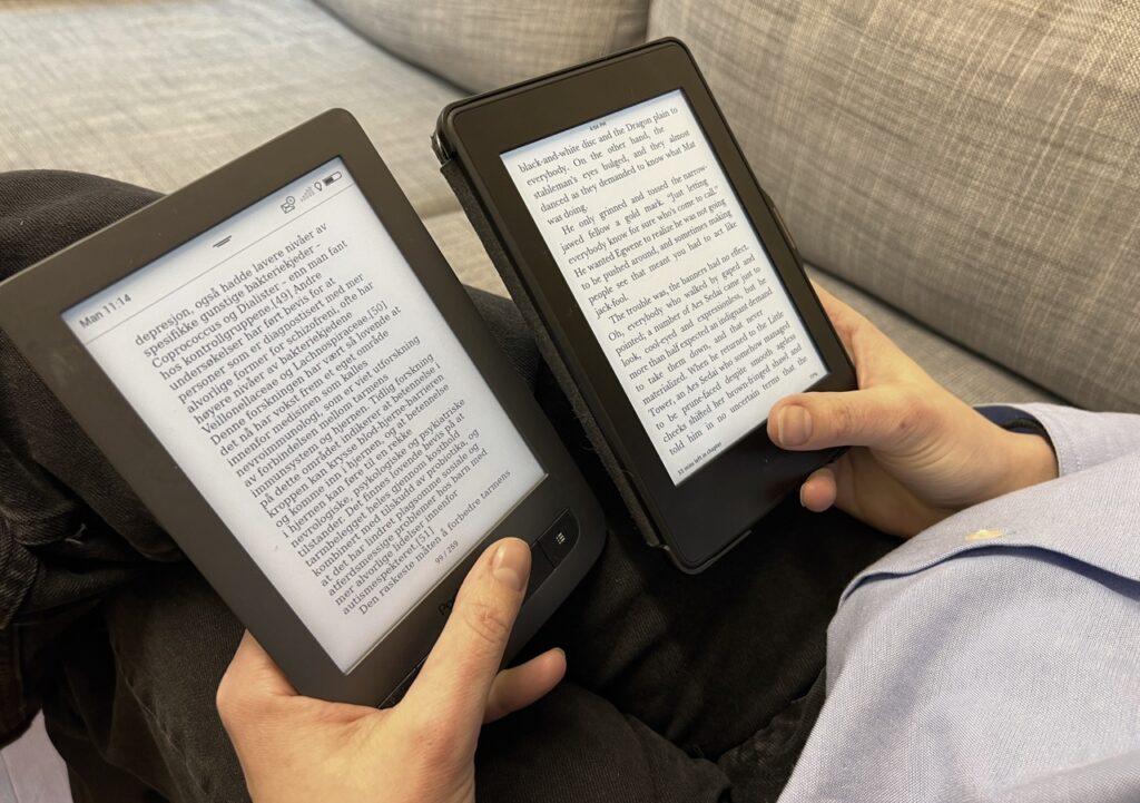 Person som sitter i sofaen og holder to lesebrett. Fokuset er på lesebrettene. Vi har sett på produkttester for å finne lesebrettene som er kåret til best i test i 2024. Blant vinnerne finner du kindle lesebrett og kobo lesebrett.