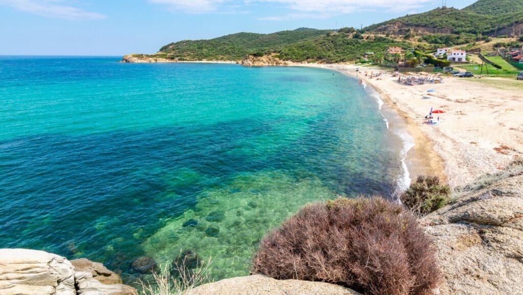 Bilde av en strand på Platanias på Kreta i Hellas. Her ser du en hvit strand med krystallklart blått hav, og grønne omgivelser. Vi hjelper deg med å finne restplasser til Kreta, mer spesifikt til Platanias på Kreta.