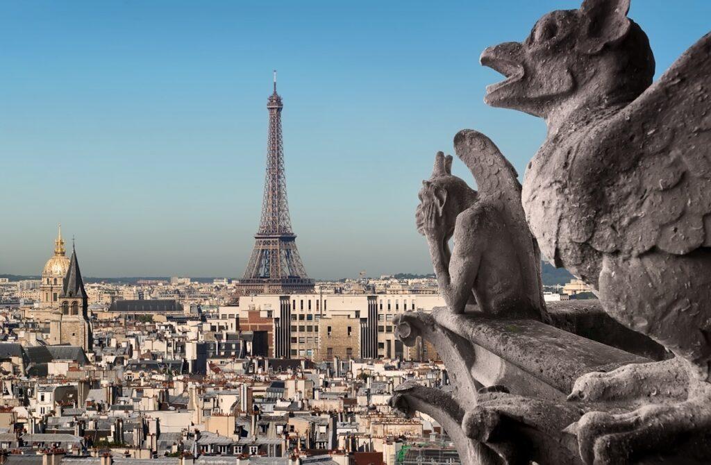 Utsiktsbilde av Paris tatt fra Notre Dame. I bakgrunnen kan du se «kjærlighetens by» med Eiffeltårnet i sentrum. I forgrunnen ser du to gargoyler. Eiffeltårnet, Triumfbuen, Louvre, Champs-Élysées og Notre Dame er alle severdigheter de fleste av oss allerede assosierer med Paris. Byen som også kalles «kjærlighetens by» kan by på mye mer en de klassiske turistfellene (som absolutt burde oppleves!), og vi har derfor samlet ti skjulte skatter du finner i Paris.