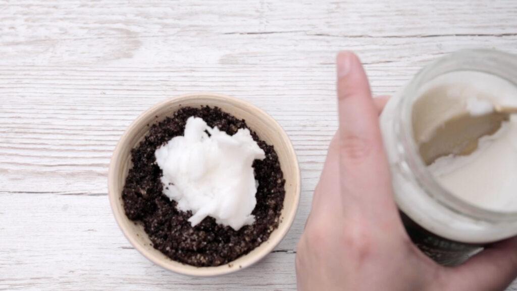 Kokosolje som blandes inn i kaffegrut for å lage en body scrub til peeling av huden.