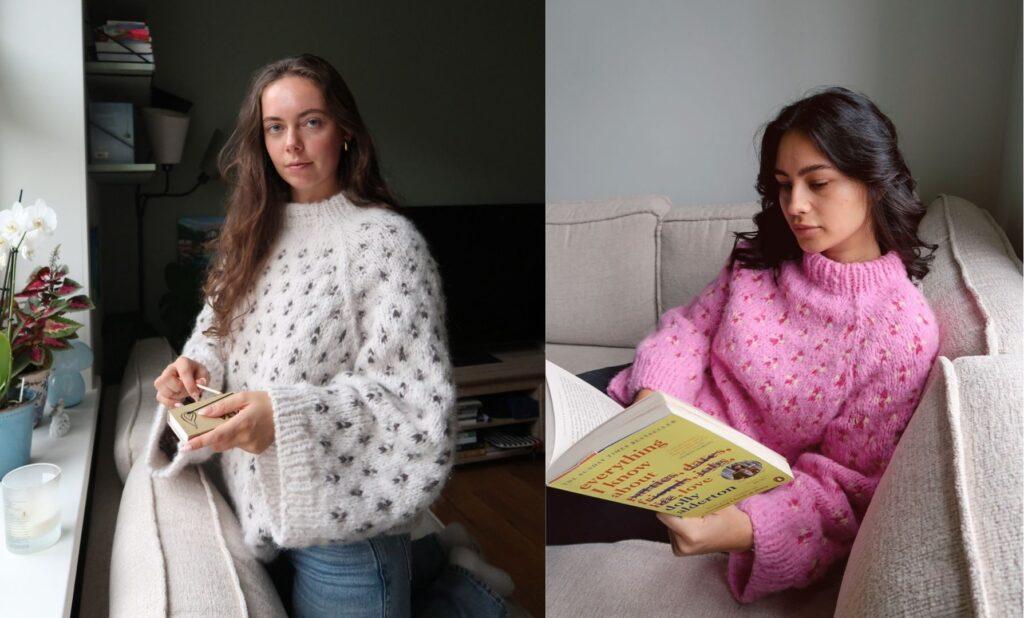 To kvinner iført den håndstrikkede Alvesmett-genseren fra Bloom by Benedicte. Den ene genseren er strikket i hvit bunnfarge med mørkegrå mønsterdetaljer, den andre i rosa bunnfarge med små detaljer i gult og rødt. Begge gensere har raglanøkninger, strukturert halskant og jevn mønsterstrikk i glattstrikk. Bildene er tatt i naturlig innemiljø med varm belysning, og genserne vises i bruk både stående og avslappet sittende.
