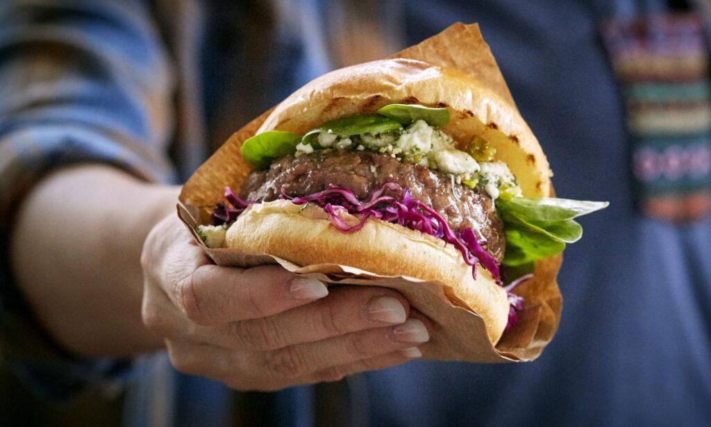 Bilde av hand som holder en lammeburger