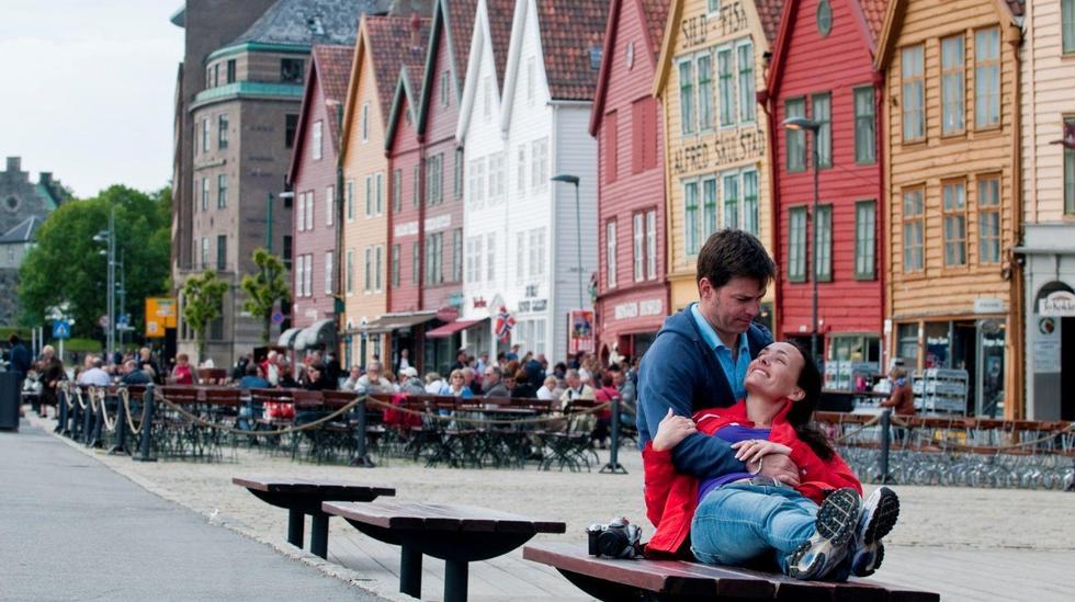 Par på benk på bryggen i Bergen.