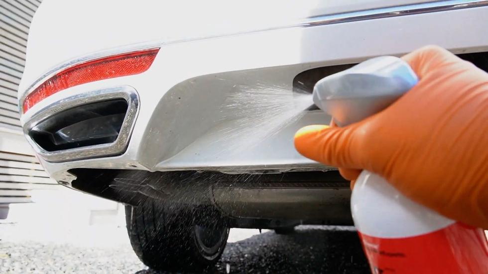 Metallpartikkelfjerner sprayes på hengerfestet på bilen som en del av bilvasken