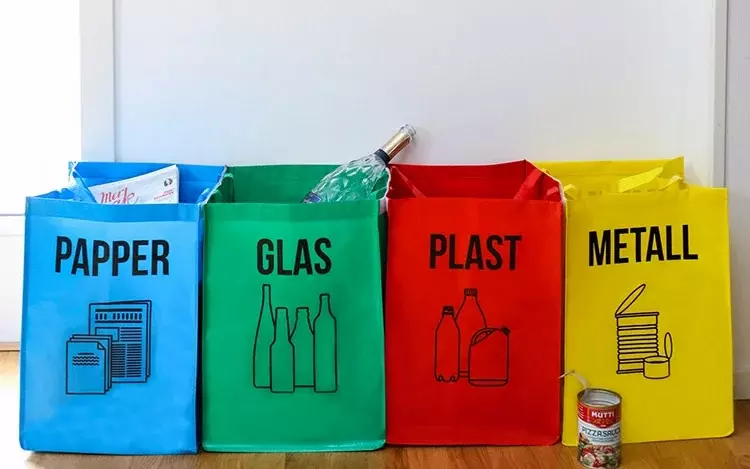 Bilde av kildesorteringsposer i blå, grønn, rød og gul med skrift til glass, papir, plast og metall. 