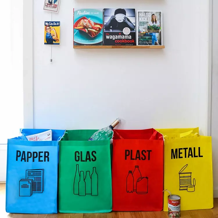 Bilde av kildesorteringsposer i blå, grønn, rød og gul med skrift til glass, papir, plast og metall.
