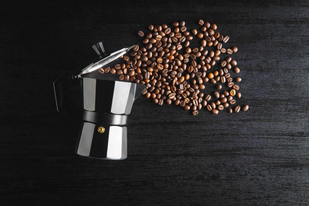 bialetti mokkabrygger lager god kaffe. avbildet på sort bakgrunn med kaffebønner.
