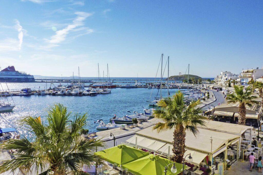 Bilde fra havnen på den vakre og populære ferieøya Naxos i Hellas. Båter, strandpromenade og en av båtene som tar deg fra øy til øy.