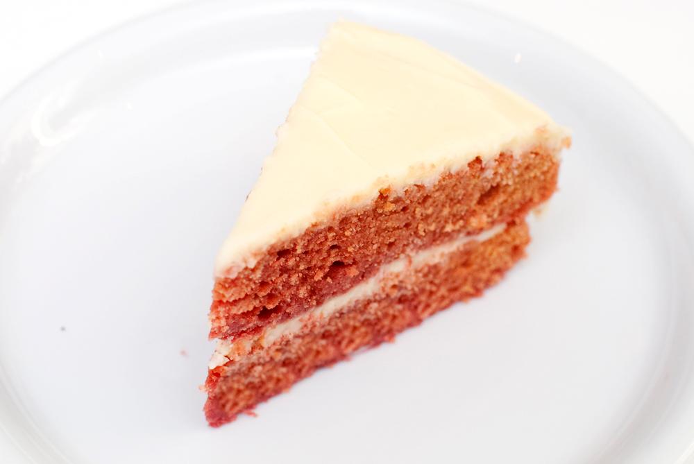 Vi deler oppskrift på vegansk red velvet kake. Her er et stykke av kaken satt frem på en tallerken.