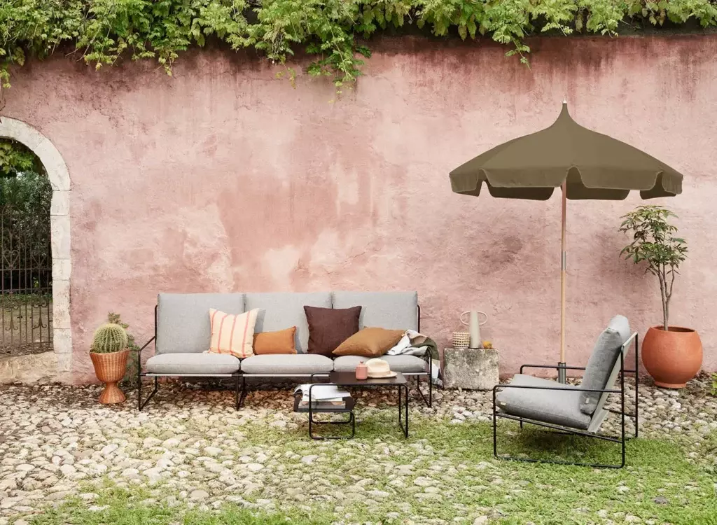 Grå hagemøbler utenfor rosa murvegg som du kan kjøpe som interiør på nett. 