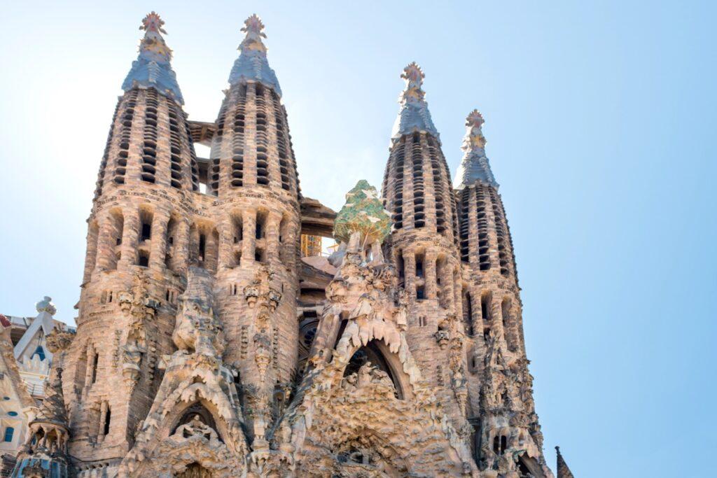 Bilde av Sagrada Familia i Barcelona med blå himmel i bakgrunnen. Her finner du fem ting du må se og oppleve i Barcelona.