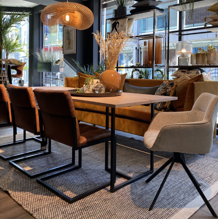 Brune spisestuestoler rundt spisebord med interiør og dekor oppå spisebord.