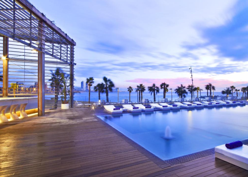Svømmebassen og solstoler på terrasse på hotell i Barcelona.