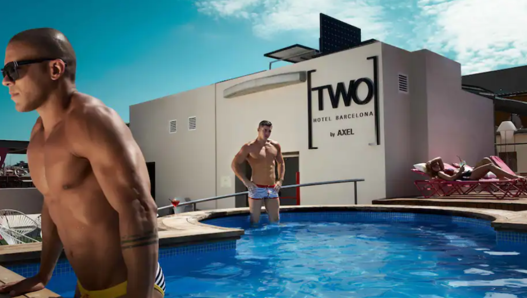 To menn i bar overkropp som bader i basseng på taket av et hotell i Barcelona.