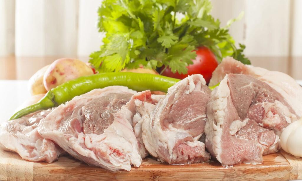 Rått lammekjøtt ligger på skjærefjøl, klart til å brukes i fårikål.