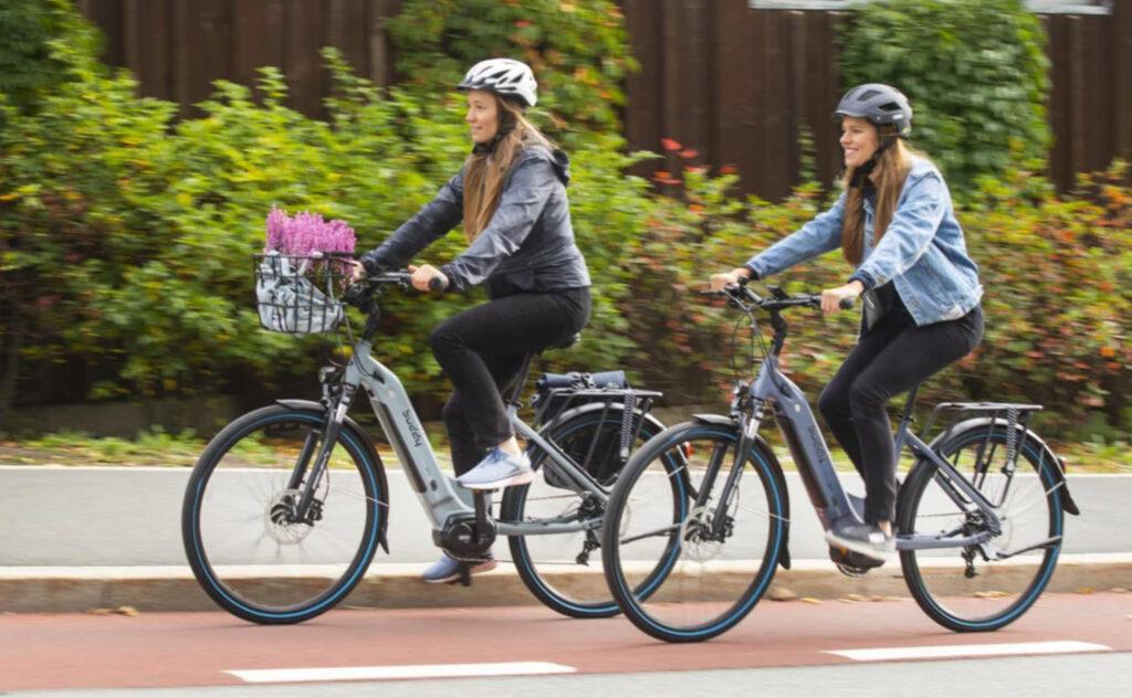 Bilde av to jenter på elsykkelen Buddy Bike D1. Den elektriske sykkelen blir anbefalt i elsykkel-tester flere år på rad. 