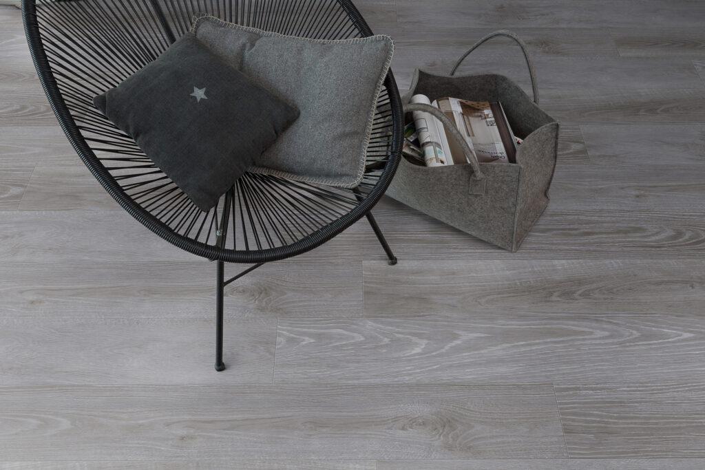 Bilde av gulv: Klikk-vinyl i grå med sort stol og pose