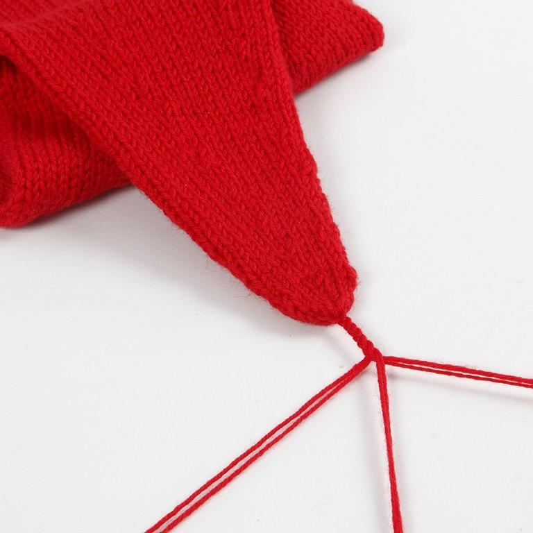Bilde av snør som består av tre tråder som skal bli flette til dusk til strikkeoppskrift på rød nisselue