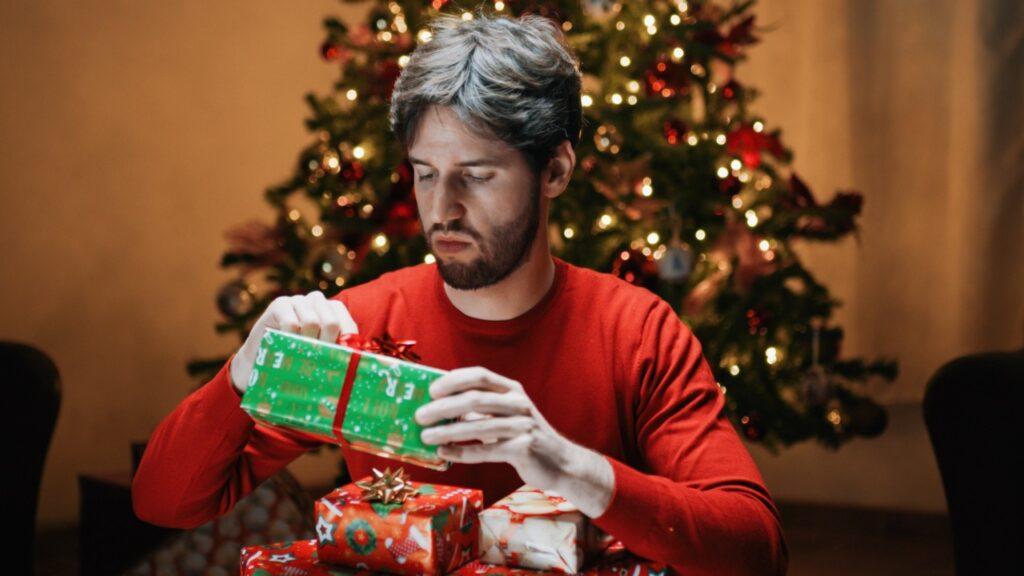 Mann som åpner julegave