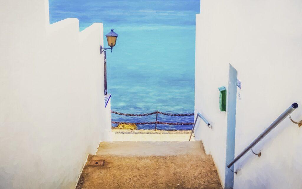 Hvite hus med trapp og utsikt til azurblått hav på Lanzarote